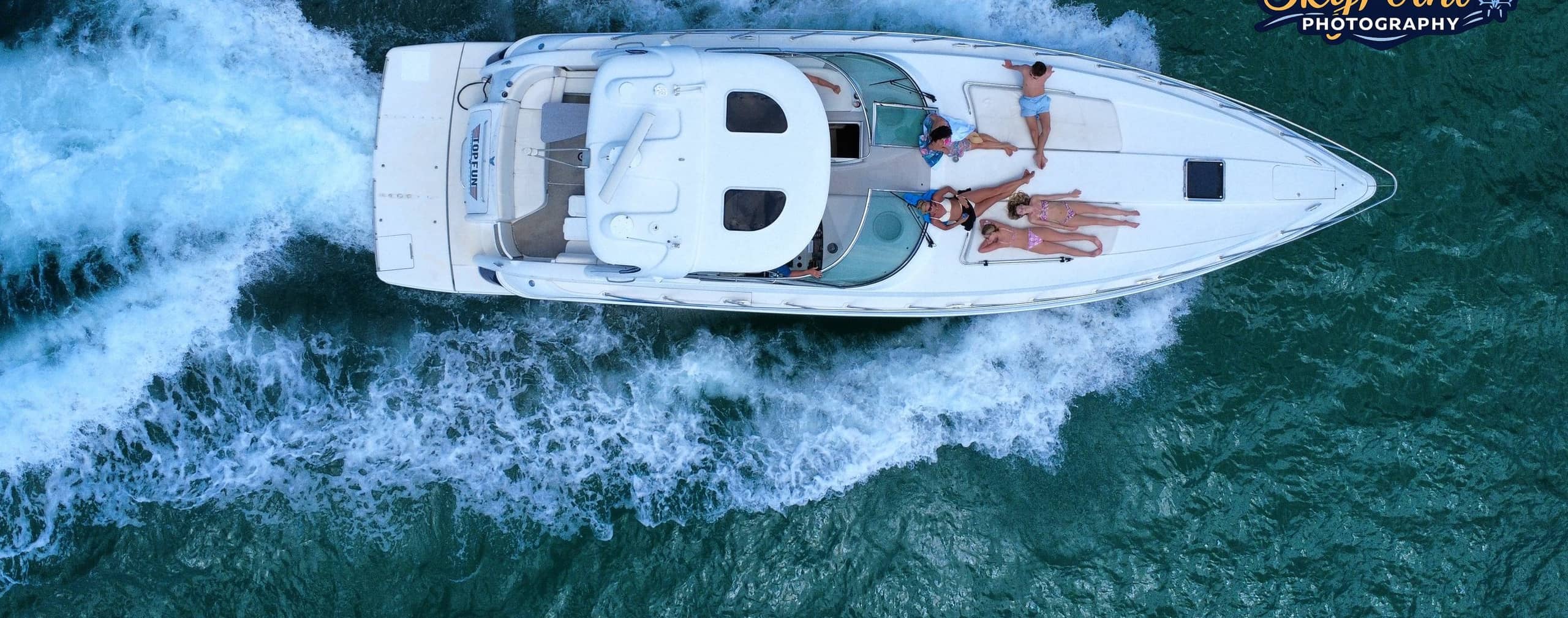 Overhead aerial of the Top Fun yacht underway with guests on the bow